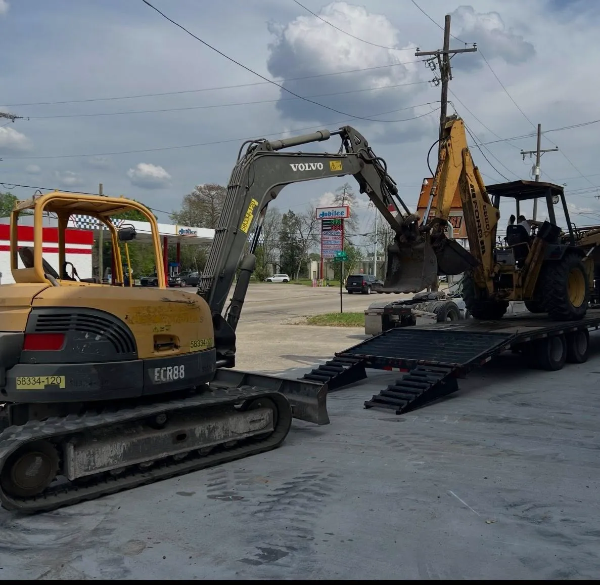 Loading an excavator and backhoe for transport to the jobsite
